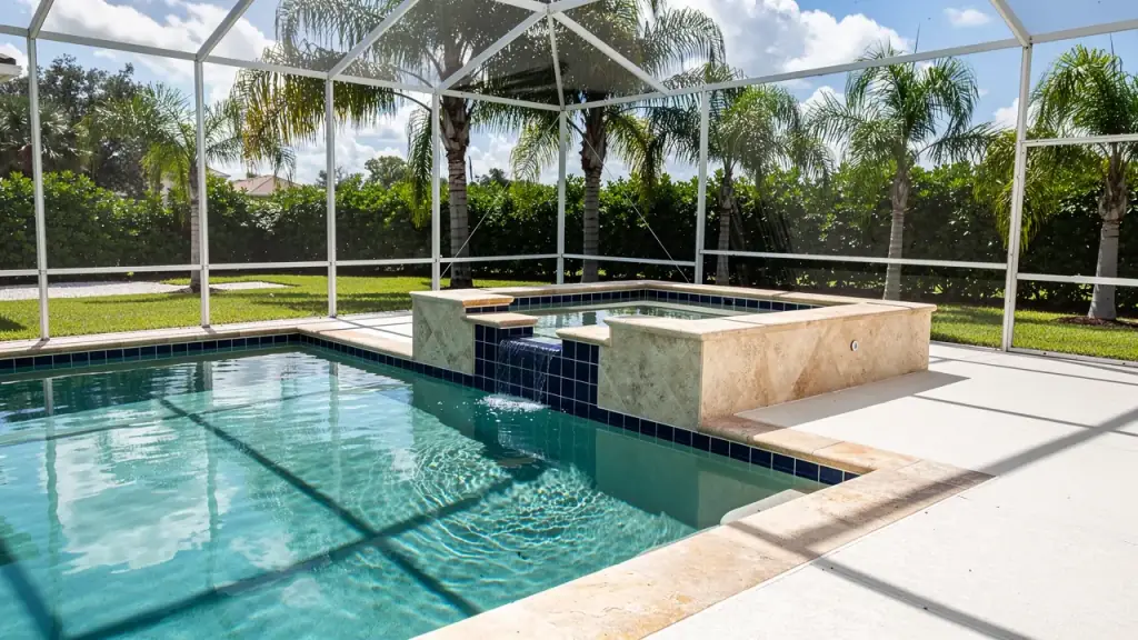Raised spa with stone coping beside a residential pool in a screened lanai